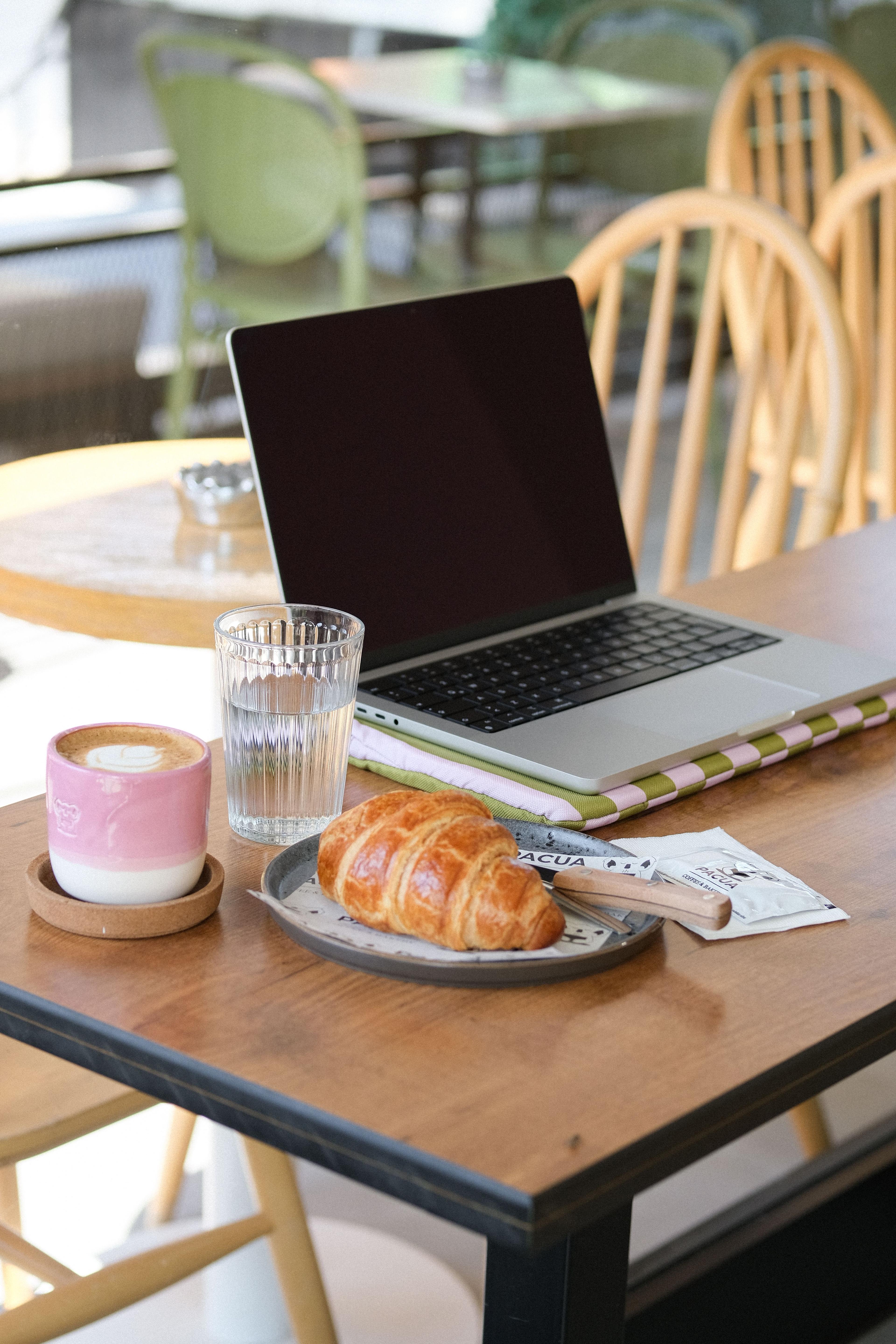 A person working on a laptop at a café table, representing a UAE remote work visa holder managing US LLC business from a local workspace.